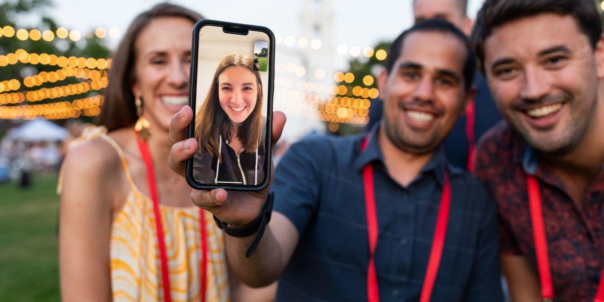 A woman appears on a Facetime call on Chapel Lawn during Reunion