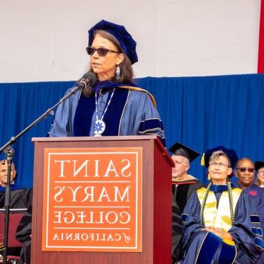  Dr. Karina Walters of the National 研究院 of Health giving the commencement address at the podium